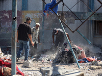 Palestinians are inspecting a UN school sheltering displaced people, following an Israeli strike, amid the Israel-Hamas conflict, in Nuseira...