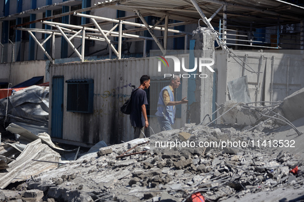 Palestinians are inspecting a UN school sheltering displaced people, following an Israeli strike, amid the Israel-Hamas conflict, in Nuseira...