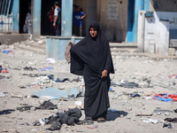 Palestinians are inspecting a UN school sheltering displaced people, following an Israeli strike, amid the Israel-Hamas conflict, in Nuseira...