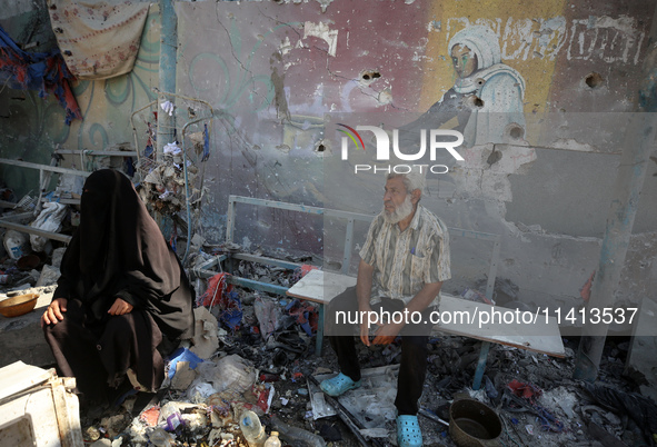 Palestinians are inspecting a UN school sheltering displaced people, following an Israeli strike, amid the Israel-Hamas conflict, in Nuseira...