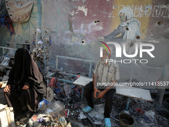 Palestinians are inspecting a UN school sheltering displaced people, following an Israeli strike, amid the Israel-Hamas conflict, in Nuseira...