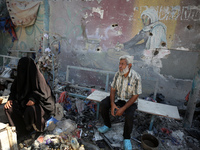 Palestinians are inspecting a UN school sheltering displaced people, following an Israeli strike, amid the Israel-Hamas conflict, in Nuseira...