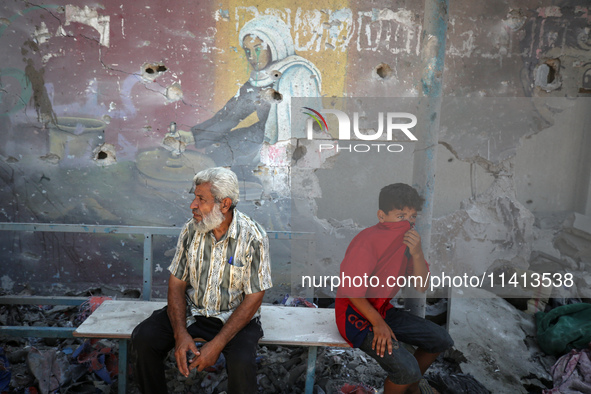 Palestinians are inspecting a UN school sheltering displaced people, following an Israeli strike, amid the Israel-Hamas conflict, in Nuseira...