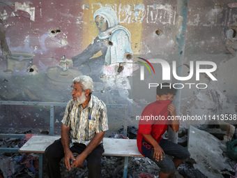 Palestinians are inspecting a UN school sheltering displaced people, following an Israeli strike, amid the Israel-Hamas conflict, in Nuseira...