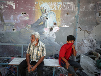 Palestinians are inspecting a UN school sheltering displaced people, following an Israeli strike, amid the Israel-Hamas conflict, in Nuseira...