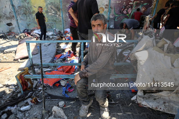 Palestinians are inspecting a UN school sheltering displaced people, following an Israeli strike, amid the Israel-Hamas conflict, in Nuseira...