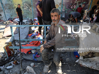 Palestinians are inspecting a UN school sheltering displaced people, following an Israeli strike, amid the Israel-Hamas conflict, in Nuseira...