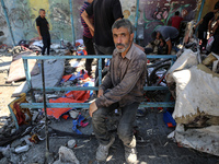 Palestinians are inspecting a UN school sheltering displaced people, following an Israeli strike, amid the Israel-Hamas conflict, in Nuseira...