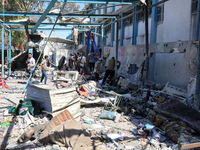 Palestinians are inspecting a UN school sheltering displaced people, following an Israeli strike, amid the Israel-Hamas conflict, in Nuseira...