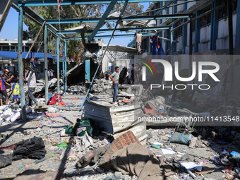 Palestinians are inspecting a UN school sheltering displaced people, following an Israeli strike, amid the Israel-Hamas conflict, in Nuseira...