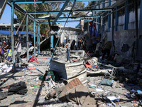 Palestinians are inspecting a UN school sheltering displaced people, following an Israeli strike, amid the Israel-Hamas conflict, in Nuseira...