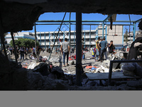 Palestinians are inspecting a UN school sheltering displaced people, following an Israeli strike, amid the Israel-Hamas conflict, in Nuseira...