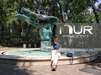 A woman is standing at the Beginning of Beginnings fountain in Greek Park on Prymorskyi Boulevard in Odesa, Ukraine, on July 13, 2024. NO US...