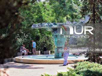 A woman is standing at the Beginning of Beginnings fountain in Greek Park on Prymorskyi Boulevard in Odesa, Ukraine, on July 13, 2024. NO US...