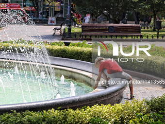 A boy is playing by a fountain on a hot summer day in Odesa, Ukraine, on July 13, 2024. NO USE RUSSIA. NO USE BELARUS. (