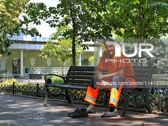 A smiling municipal worker is sitting on the bench in the shadow on a hot summer day in Odesa, Ukraine, on July 13, 2024. NO USE RUSSIA. NO...