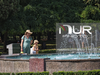 A woman and girl are staying by a fountain in Odesa, Ukraine, on July 13, 2024. NO USE RUSSIA. NO USE BELARUS. (