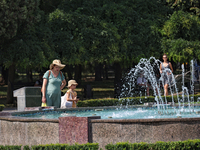 A woman and girl are staying by a fountain in Odesa, Ukraine, on July 13, 2024. NO USE RUSSIA. NO USE BELARUS. (