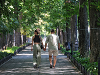 A man and woman are walking hand in hand along an alley on a hot summer day in Odesa, Ukraine, on July 13, 2024. NO USE RUSSIA. NO USE BELAR...