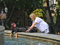 Two women are cooling their hands in a fountain on a hot summer day in Odesa, Ukraine, on July 13, 2024. NO USE RUSSIA. NO USE BELARUS. (