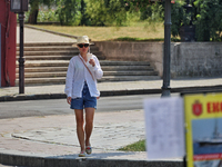 A woman in a hat and sunglasses is drinking a beverage on a hot summer day in Odesa, Ukraine, on July 13, 2024. NO USE RUSSIA. NO USE BELARU...