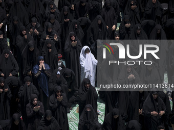 Veiled Iraqi women living in Iran are praying during a religious festival to commemorate Ashura, in Dolatabad neighborhood in southern Tehra...