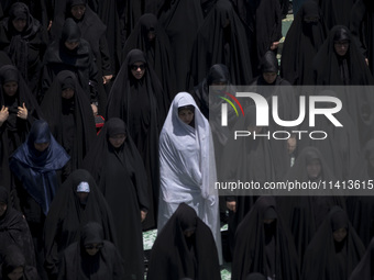 Veiled Iraqi women living in Iran are praying during a religious festival to commemorate Ashura, in Dolatabad neighborhood in southern Tehra...