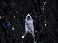 Veiled Iraqi women living in Iran are praying during a religious festival to commemorate Ashura, in Dolatabad neighborhood in southern Tehra...