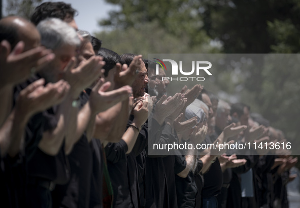 Iraqi men living in Iran are praying during a religious festival to commemorate Ashura in the Dolatabad neighborhood in southern Tehran, Ira...