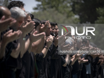 Iraqi men living in Iran are praying during a religious festival to commemorate Ashura in the Dolatabad neighborhood in southern Tehran, Ira...