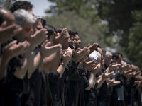 Iraqi men living in Iran are praying during a religious festival to commemorate Ashura in the Dolatabad neighborhood in southern Tehran, Ira...