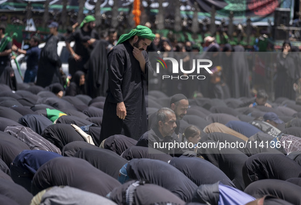 Iraqi men living in Iran are praying during a religious festival to commemorate Ashura in the Dolatabad neighborhood in southern Tehran, Ira...