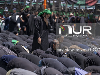 Iraqi men living in Iran are praying during a religious festival to commemorate Ashura in the Dolatabad neighborhood in southern Tehran, Ira...