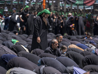 Iraqi men living in Iran are praying during a religious festival to commemorate Ashura in the Dolatabad neighborhood in southern Tehran, Ira...