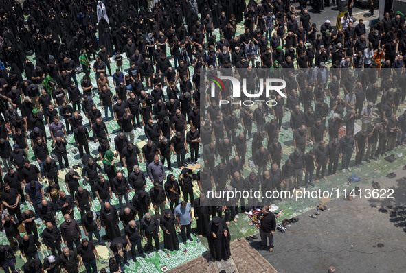 Iraqi men and women living in Iran are praying during a religious festival to commemorate Ashura in the Dolatabad neighborhood in southern T...