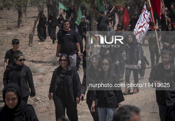 Young women are walking together along an area, while participating in a religious festival to commemorate Ashura, in Dolatabad neighborhood...