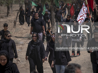 Young women are walking together along an area, while participating in a religious festival to commemorate Ashura, in Dolatabad neighborhood...