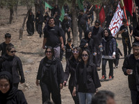 Young women are walking together along an area, while participating in a religious festival to commemorate Ashura, in Dolatabad neighborhood...