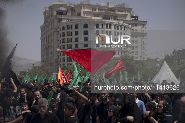 Iraqi men living in Iran are waving religious flags while participating in a religious festival to commemorate Ashura in the Dolatabad neigh...