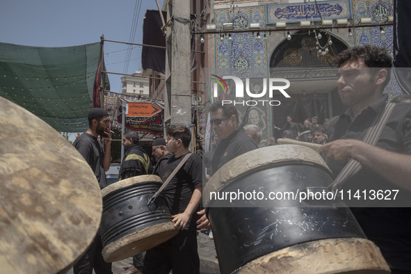 Iraqi men living in Iran are carrying traditional musical instruments while participating in a religious festival to commemorate Ashura in t...