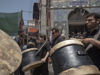 Iraqi men living in Iran are carrying traditional musical instruments while participating in a religious festival to commemorate Ashura in t...