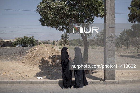 Two veiled Iraqi women are standing together on a street side after participating in a religious festival to commemorate Ashura, in Dolataba...