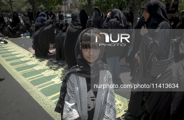 A young girl is posing for a photograph while veiled women are preparing to take part in a mass prayer ceremony during a religious festival...