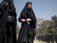 A veiled woman is looking on while participating in a religious festival to commemorate Ashura, in Dolatabad neighborhood in southern Tehran...