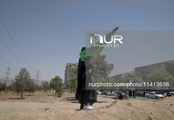 A young veiled Iraqi girl living in Iran is holding a religious flag during a religious festival to commemorate Ashura in the Dolatabad neig...