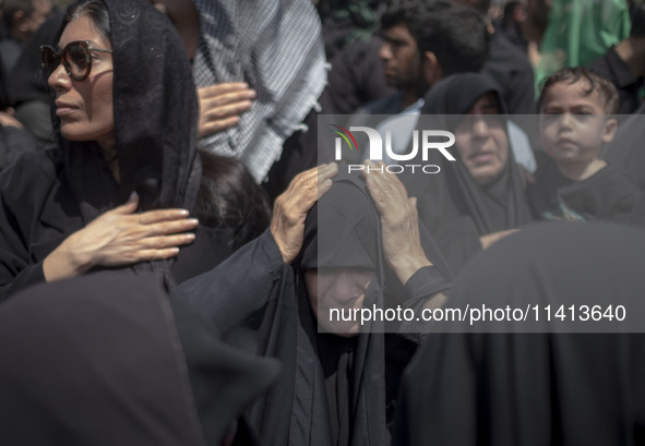 An Iraqi woman living in Iran is beating herself while participating in a religious festival to commemorate Ashura in the Dolatabad neighbor...