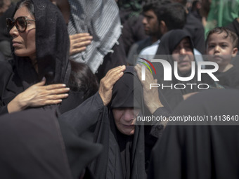 An Iraqi woman living in Iran is beating herself while participating in a religious festival to commemorate Ashura in the Dolatabad neighbor...