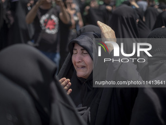 A veiled woman is beating herself while participating in a religious festival to commemorate Ashura, in Dolatabad neighborhood in southern T...