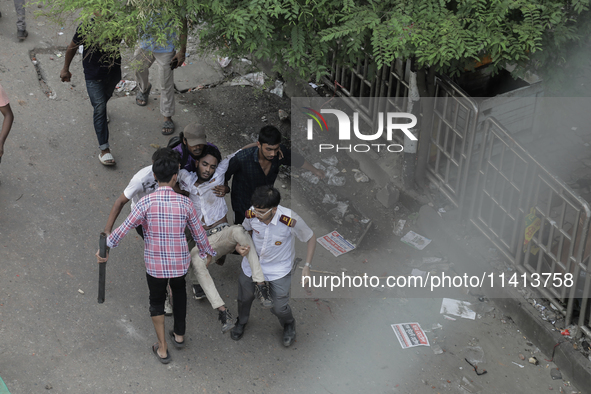 An injured anti-quota protestor is being taken to a hospital during a clash with the pro-government student wing in Dhaka, Bangladesh, on Ju...