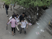 An injured anti-quota protestor is being taken to a hospital during a clash with the pro-government student wing in Dhaka, Bangladesh, on Ju...